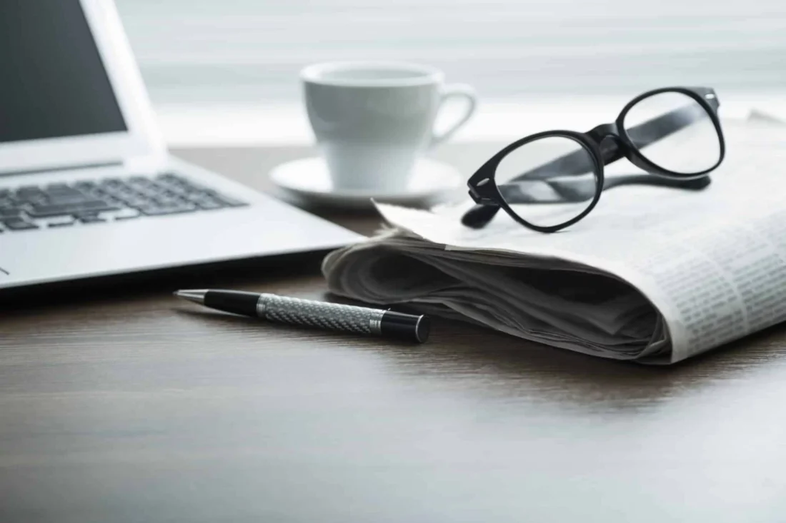 Business professional typing on laptop with Forbes website open, representing the value of a Forbes Council membership.