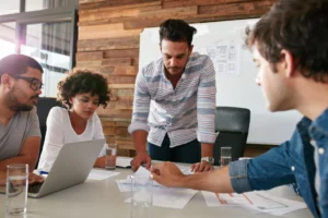 Team of professionals reviewing documents during a strategy meeting, emphasizing the importance of how to choose the right PR agency.