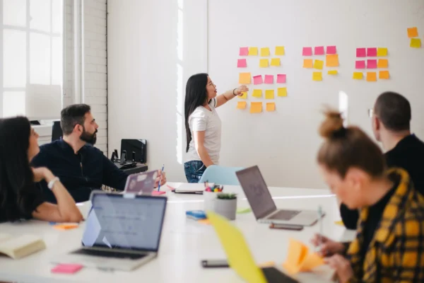 Team at an enterprise B2B tech PR agency collaborating during a strategy session with colorful sticky notes on a wall.