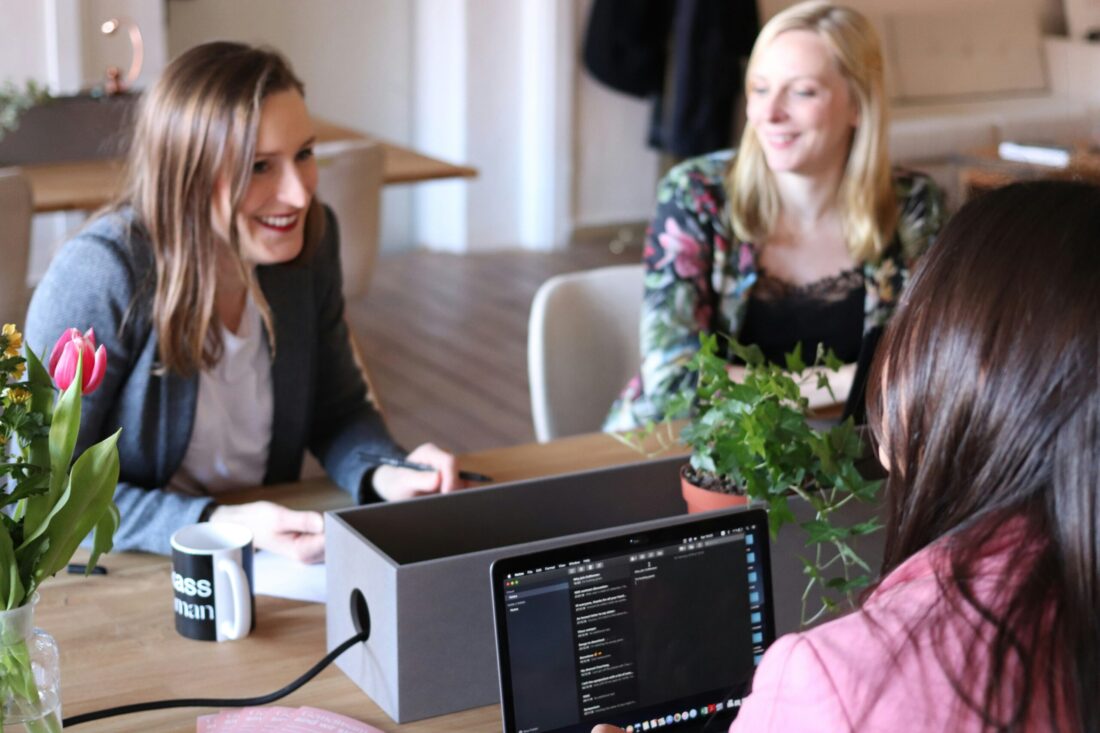 Business professionals collaborating around a laptop during a strategy discussion illustrating how to make a PR agency switch for better alignment and results.