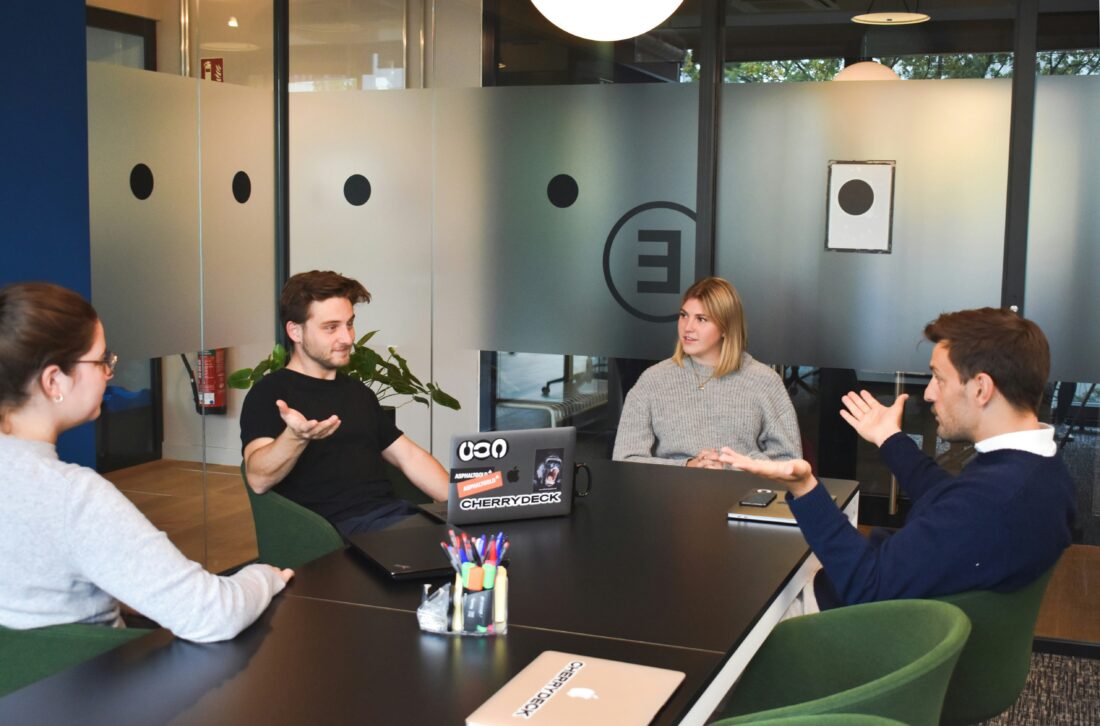 B2B technology team discussing a PR agency service model in a conference room.