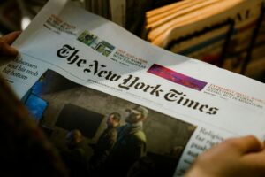 Person reading a newspaper, illustrating how to get media coverage for a SaaS company by developing stories journalists consider relevant and publishable.