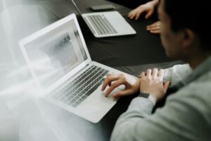 B2B professionals working on laptops, illustrating how B2B brands improve AI visibility through digital content, research, and online brand presence.